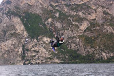 Sitzender Kitesurfer bei einem Sprung am Gardasee.