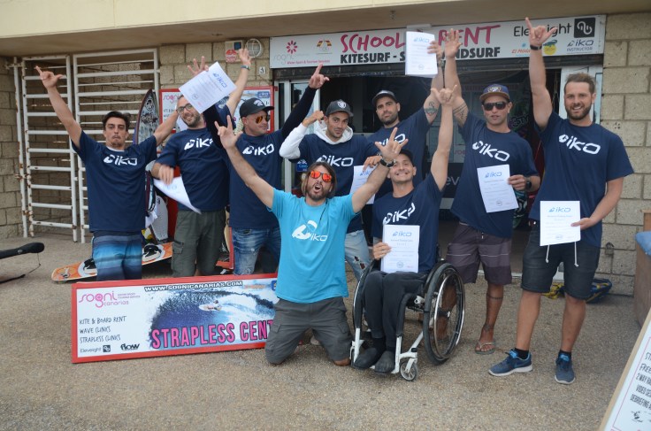 A group of men, all with IKO t-shirts making the hang loose sign with their hands.