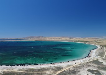 A drone-foto of the bay. In the turqoise water you can see the white lines produced by kiters and windsurfers.